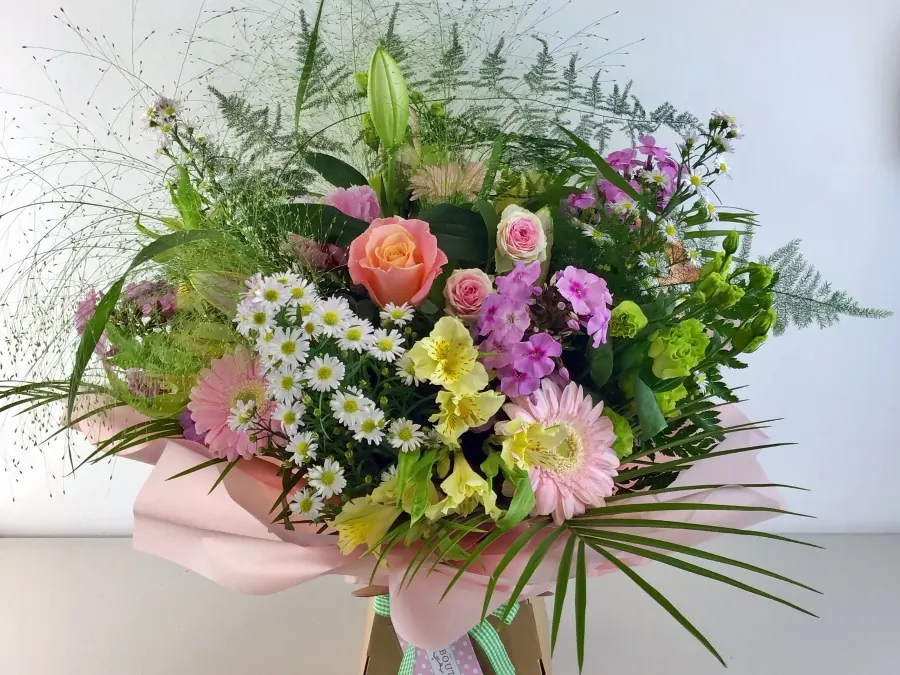 Hand-tied bouquet of peach roses, pink gerberas, white daisies and lilies with fern fronds in a gift box, by The Petal Boutique